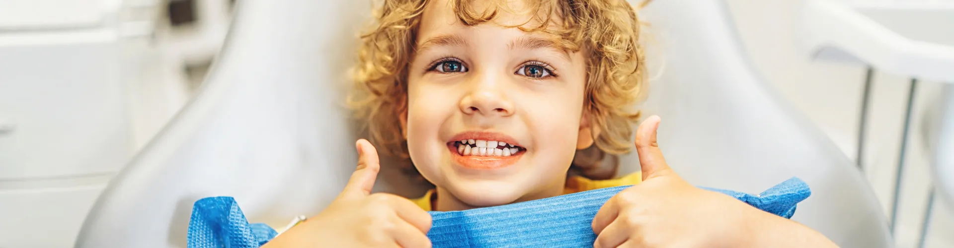 Smiling boy giving thumbs-up with both hands.