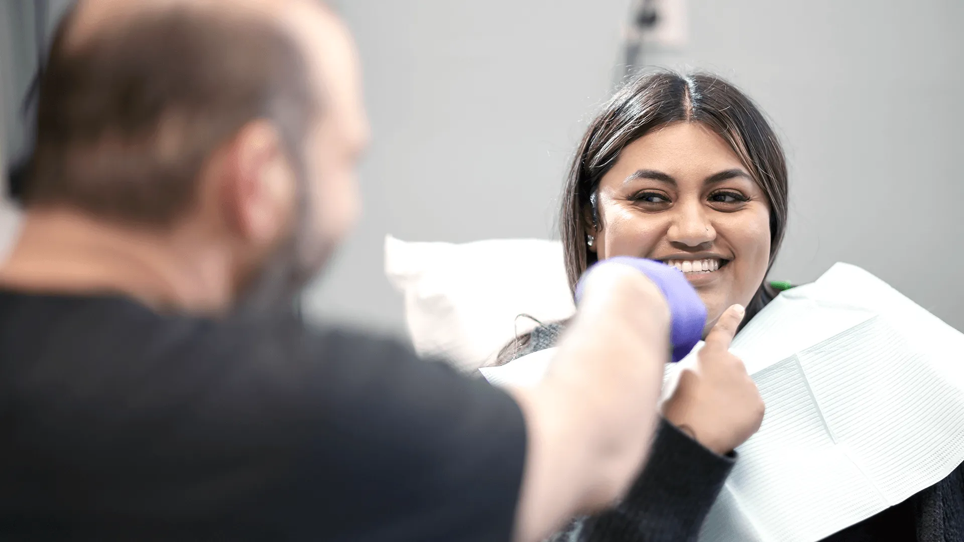 A dental specialist in a clinic discussing cosmetic procedures with a patient, focusing on aesthetic smile improvements.