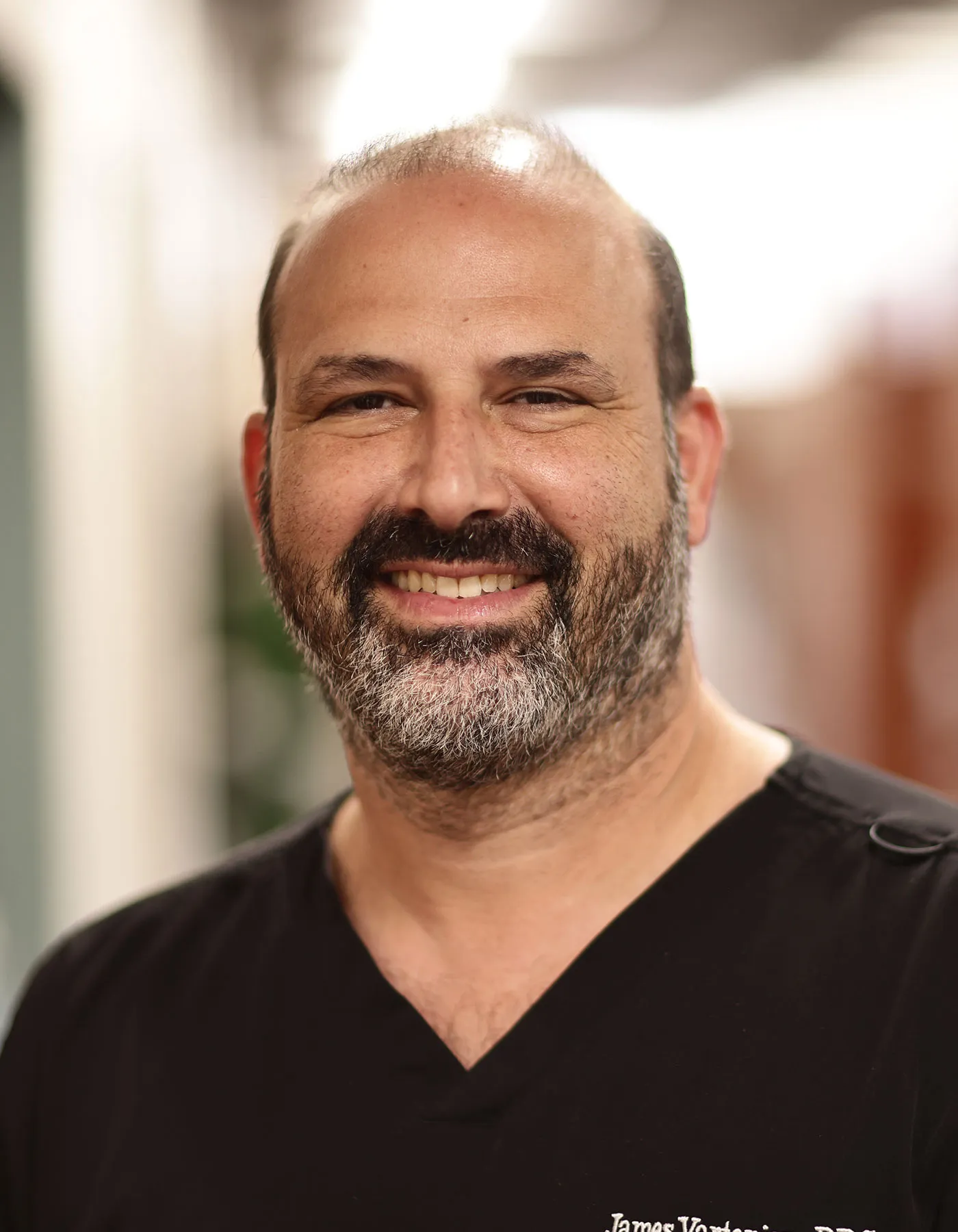 Portrait of Dr. James Vartanian wearing a black medical shirt.