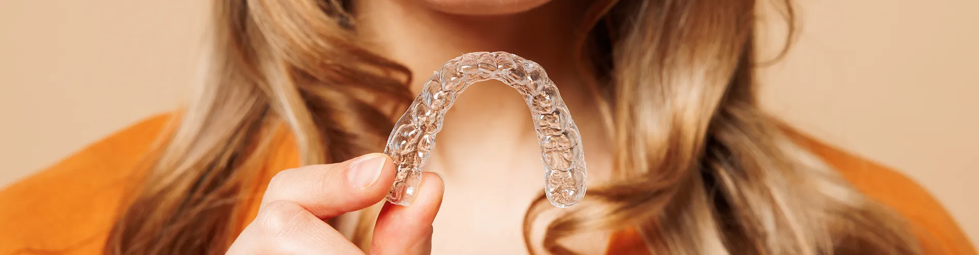 Woman smiling while showing invisalign